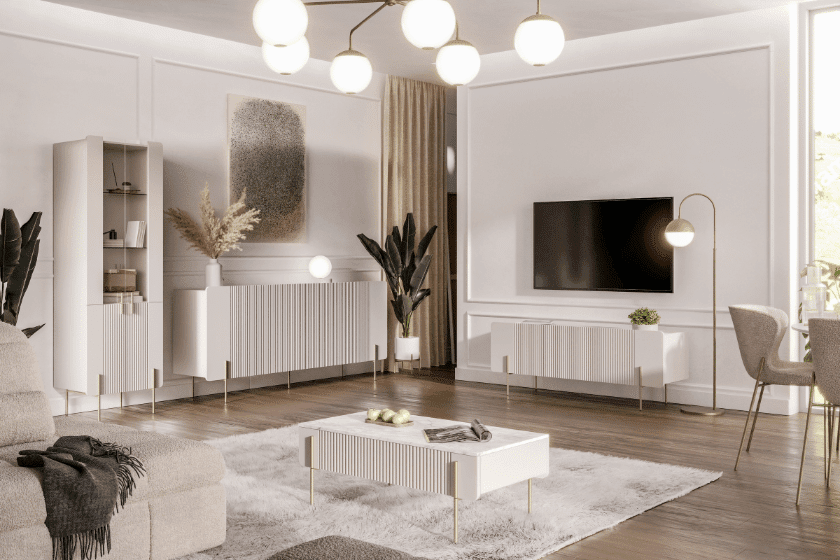 Elegancki salon w jasnych barwach z nowoczesnym zestawem mebli o ryflowanych frontach i złotych nóżkach, inspirowany stylem glamour.