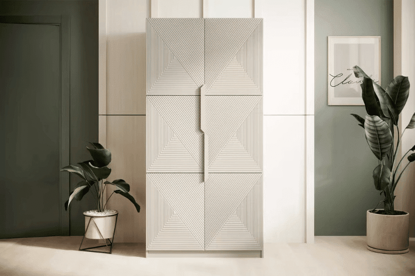 Designerska szafa o geometrycznych frontach w jasnym wnętrzu z zielonymi akcentami i roślinnymi dekoracjami.