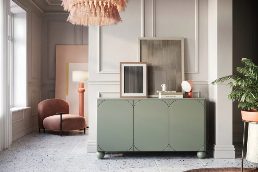 Elegancki salon z zieloną komodą, różowym fotelem i designerską lampą piórkową